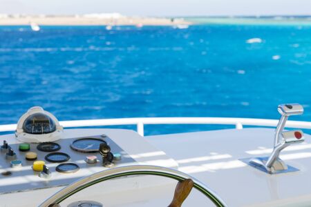 Yacht steering wheel on blue sky background. The yacht's steering wheel sails on the sea.