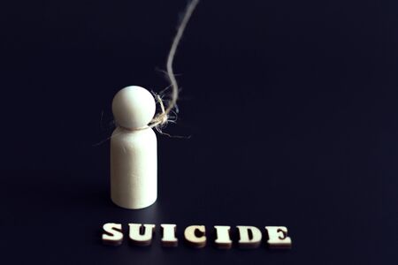 Suicide and depression concept. figurine of a man in a loop and the inscription suicide on a black...