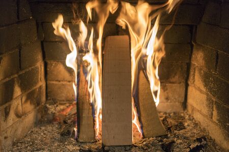 A fire burns in a fireplace, Fire to keep warm. Close up shot of burning firewood in the fireplace.
