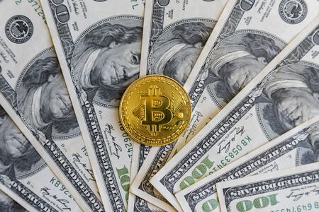 Physical version of bitcoin with one hundred dollars. golden bitcoin coin on us dollars. Mining and...