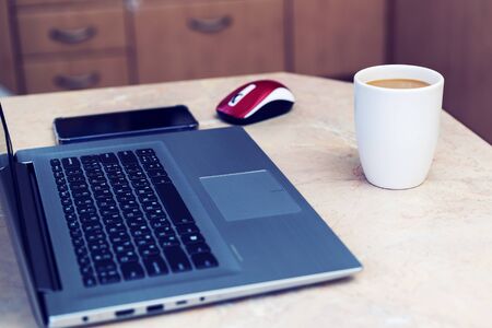 High angle view of an empty workplace. Laptop with coffee cup home office. Close up view of a work desk interior with a laptop computer, a cup of coffee. tonedの写真素材