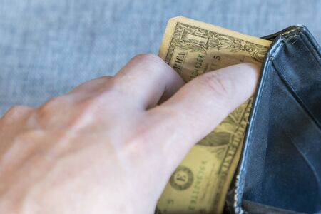 Hand holding black leather wallet with dollar money bank note to pay for import export economy...