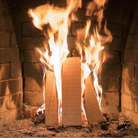 A fire burns in a fireplace, Fire to keep warm. Close up shot of burning firewood in the fireplace.