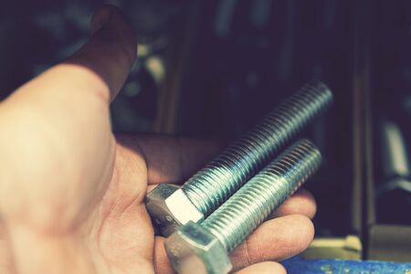 hand holds an iron bolt. repair concept. close-up.の写真素材