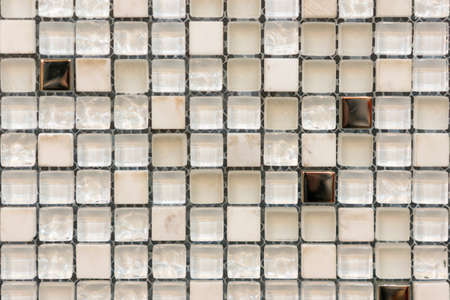 Ceramic mosaic tiles with white and brown embossed squares to decorate the kitchen, bathroom or pool. Mosaic of brown marble in the form of squaresの写真素材