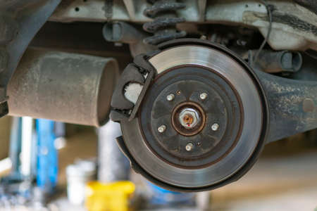 The hub of a wheel in a car service. Suspended car with no wheels. Suspension of car in service room.The car lift up by lifter for maintenance suspension and cleaning parts. Close upの写真素材
