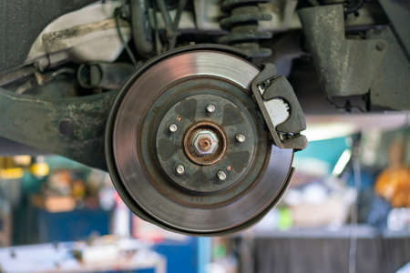 The hub of a wheel in a car service. Suspended car with no wheels. Suspension of car in service room.The car lift up by lifter for maintenance suspension and cleaning parts. Close upの写真素材