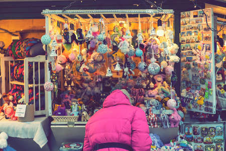 Woman choosing toys at Christmas market. woman chooses souvenirs at the Christmas market. back view. tonedの写真素材