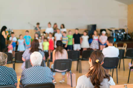 Children's holiday in elementary School. Children on stage perform in front of parents. image of blur kid 's show on stage at school, for background usage. Blurry. toned.の写真素材