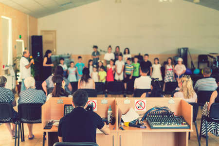 Childrens holiday in elementary School. Children on stage perform in front of parents. image of blur kid s show on stage at school , for background usage. Blurry. tonedの写真素材
