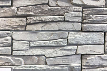 Stacked stone wall, natural stone cladding. Stone wall for background,Slab stone wall texture. Wall background of volcanic andesite basalt stone textureの写真素材