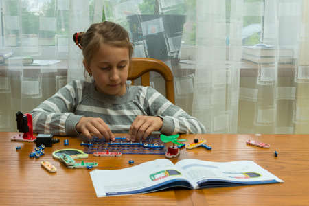 Positive lady playing with toy. She making it from constructor. Entertainment concept. Education, children, technology, science and futuristic concept. E-learning. tonedの写真素材