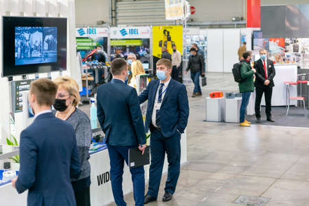 Kiev, Ukraine November 25 2020. Industrial Exhibition during a pandemic. People at the exhibition wearing medical masks. Exhibition and social distanceのeditorial素材