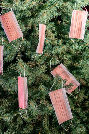 Christmas tree decorated with medical disposable medical masks. Celebrating new 2021 year during  pandemic. vertical photoの写真素材
