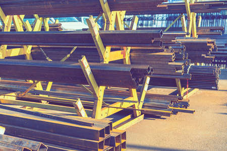 stack of steel pipe and metal beams on rack. metal pipes, profiles, rods, corners, rails, a choice of metal products. Metal shop. tonedの写真素材