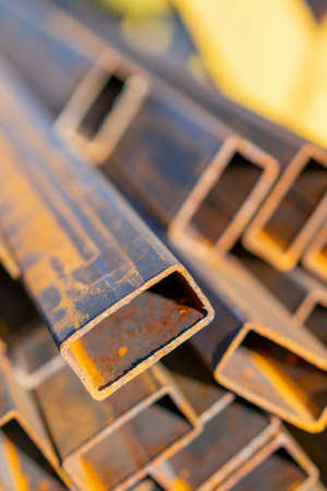stack of steel pipe and metal beams on rack. metal pipes, profiles, rods, corners, rails, a choice of metal products. vertical photoの写真素材