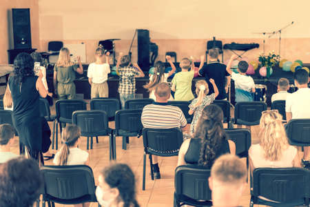 Childrens holiday in elementary School. Children on stage perform in front of parents. image of blur kid s show on stage at school , for background usage. Blurry. tonedの写真素材
