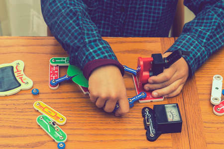 The boy playing an electric constructor. The child is played by intellectual toys. A boy in a blue...