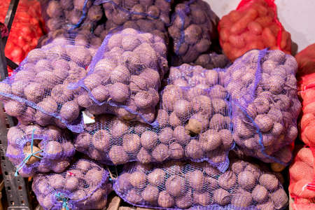 potatoes in stored in netting for distribution to market. Bags with potatoes. potatoes in bags close-up, a lot of potatoes, a store or marketの写真素材