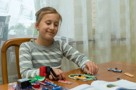 Positive lady playing with toy. She making it from constructor. Entertainment concept. Education, children, technology, science and futuristic concept. E-learning. tonedの写真素材
