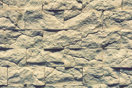 Stacked stone wall, natural stone cladding. Stone wall for background. Wall background of volcanic andesite basalt stone texture. tonedの写真素材