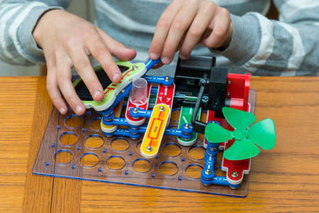 Cropped shot of a girl building a robot details close up education science technology robotics futuristic electronic mechanic developing creativity constructor playing toys concept. toned.の写真素材