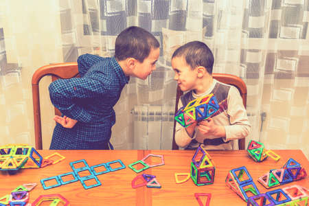 Children Boys playing with construction set on the floor.Educational games for kids. Boys playing whit blocks. Kindergarten. tonedの写真素材