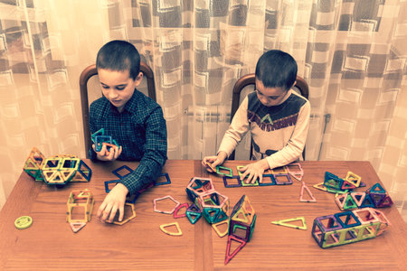 Children Boys playing with construction set on the floor.Educational games for kids. Boys playing...
