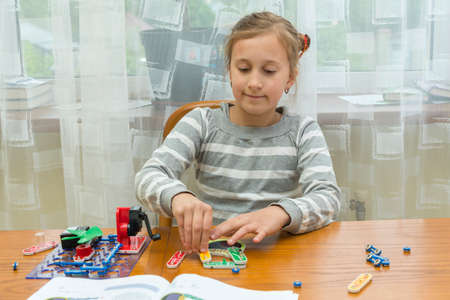 Positive lady playing with toy. She making it from constructor. Entertainment concept. Education, children, technology, science and futuristic concept. E-learning. tonedの写真素材