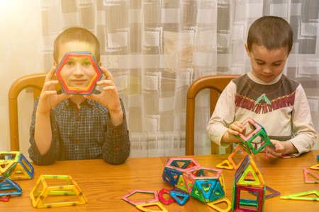 Children Boys playing with construction set on the floor.Educational games for kids. Boys playing whit blocks. Kindergarten. tonedの写真素材