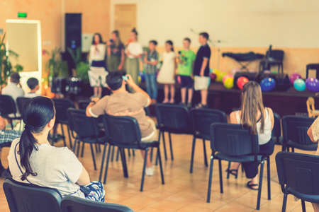 Childrens holiday in elementary School. Children on stage perform in front of parents. image of blur kid s show on stage at school , for background usage. Blurry. tonedの写真素材