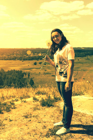 Happy, beautiful middle-aged woman with long hair on the background of a summer field. Healthy lifestyle and travel concept. Loneliness, unity with nature. tonedの写真素材