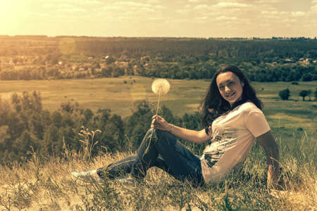 Happy, beautiful middle-aged woman with long hair on the background of a summer field. Healthy lifestyle and travel concept. Loneliness, unity with nature. tonedの写真素材