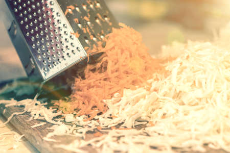 Woman rubbing carrots. Sauerkraut with carrots. Pickled cabbage. Sauerkraut cooking process. tonedの写真素材