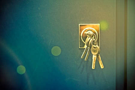 Keys stuck in a lock. closeup Door lock keys, Real estate concept door handle, Key insert and hold in metallic knob on white door horizontal. tonedの写真素材