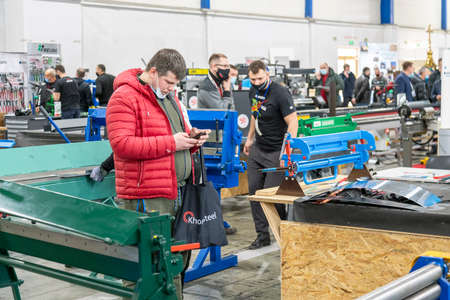 Kiev, Ukraine March 18 2021. international building exhibitionduring a pandemic. Equipment for construction and repair. Business meetings at the exhibition. Exhibition and social distance.のeditorial素材