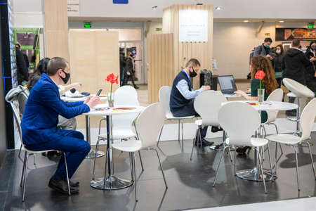 Kiev, Ukraine March 18 2021. international building exhibitionduring a pandemic. Equipment for construction and repair. Business meetings at the exhibition. Exhibition and social distance.のeditorial素材