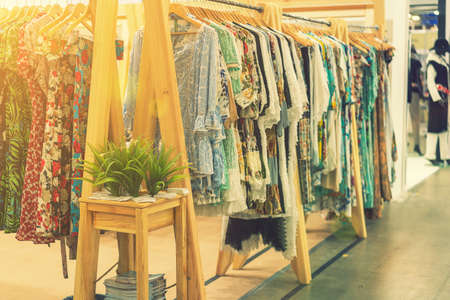 spring and summer womens clothing in the store. bright, modern clothes in a boutique. Womens hip clothing store interior concept. concept of choice of clothing. tonedの写真素材