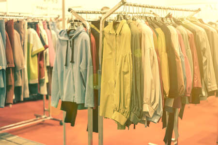spring and summer womens clothing in the store. bright, modern clothes in a boutique. Womens hip clothing store interior concept. concept of choice of clothing. tonedの写真素材