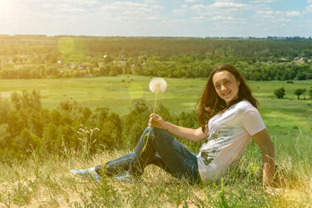 Happy, beautiful middle-aged woman with long hair on the background of a summer field. Healthy lifestyle and travel concept. Loneliness, unity with nature. tonedの写真素材