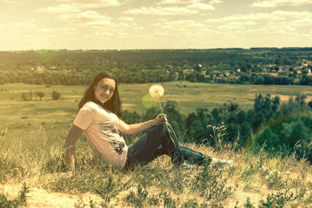 Happy, beautiful middle-aged woman with long hair on the background of a summer field. Healthy lifestyle and travel concept. Loneliness, unity with nature. tonedの写真素材
