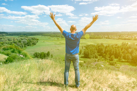 Young man standing in a wheat field with sunrise on the background. A view from the back of a women standing on a mountain and admires the beautiful view sunset. tonedの写真素材