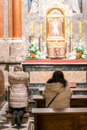 A woman in a temple prays to God. Woman praying in front of altar. Praying woman in front of altar....