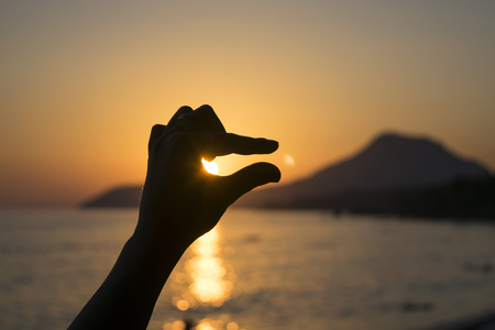 Hand on sunset backgroundの写真素材