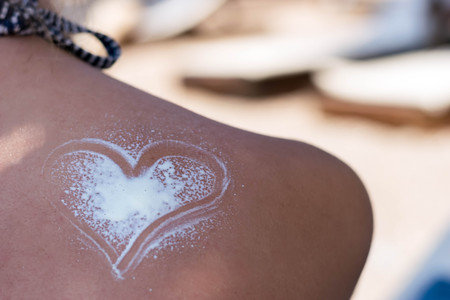 Young woman on the beach with sun protective lotionの写真素材
