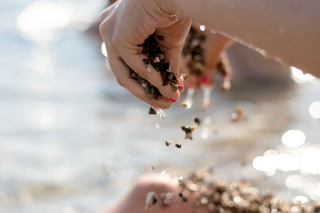 The girl holds in hands pebble stones
