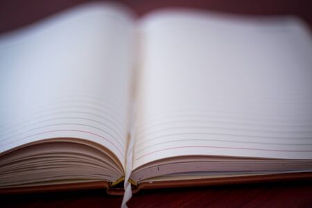 Blank open notebook with pen on wooden deskの写真素材