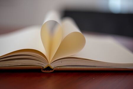 Heart from page of book concept with blurred bright light background and vintage toneの写真素材