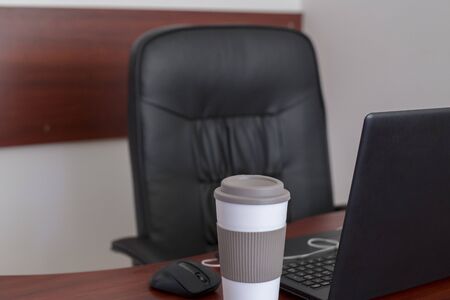 Wood office desk table with laptop, cup of coffeeの写真素材