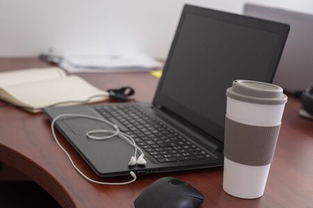 Wood office desk table with laptop, cup of coffee